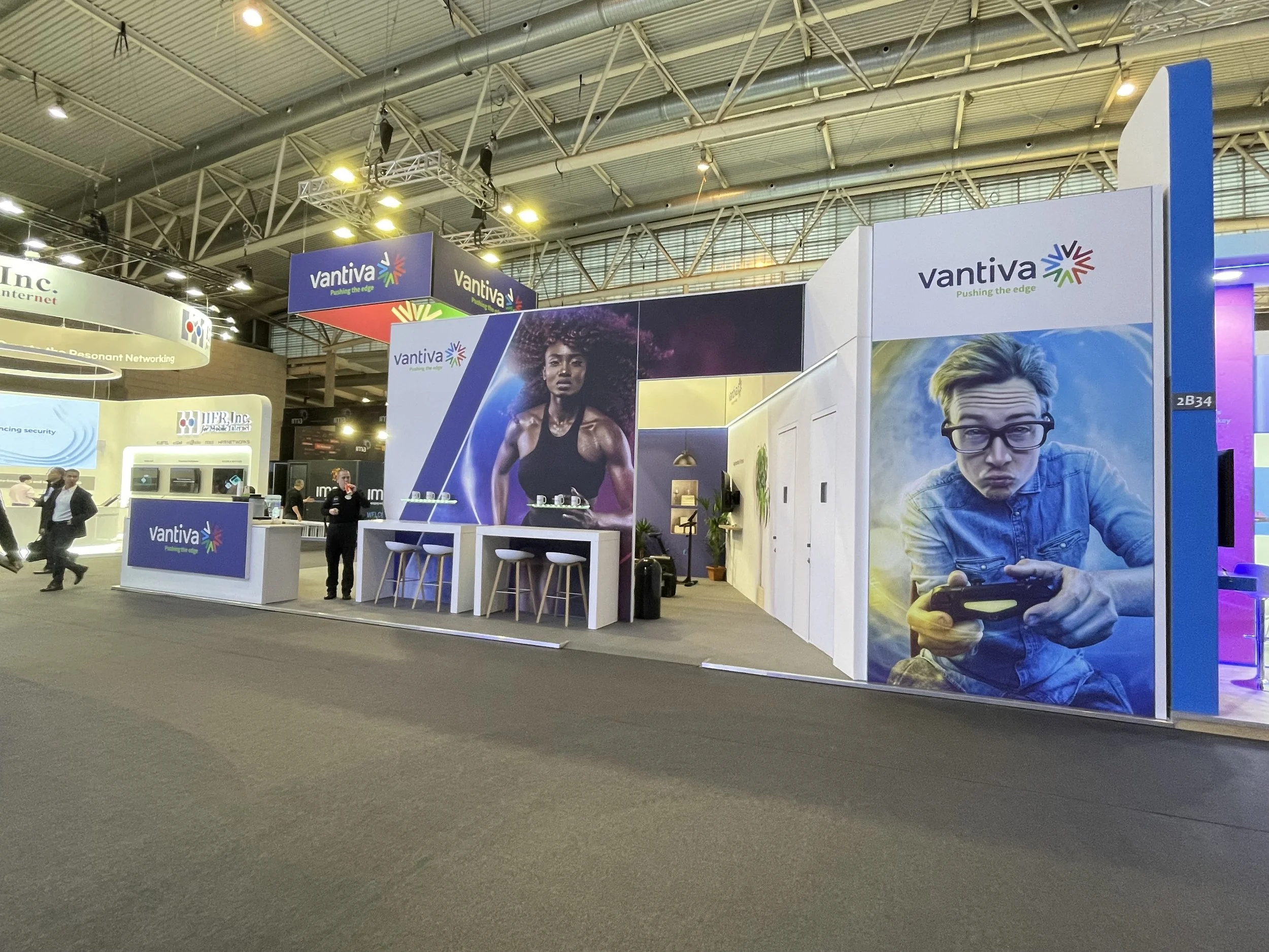 MWC Barcelona large scale image of B2B corporate booth wide angle shot with people walking on the left.  Taken right before doors open. 