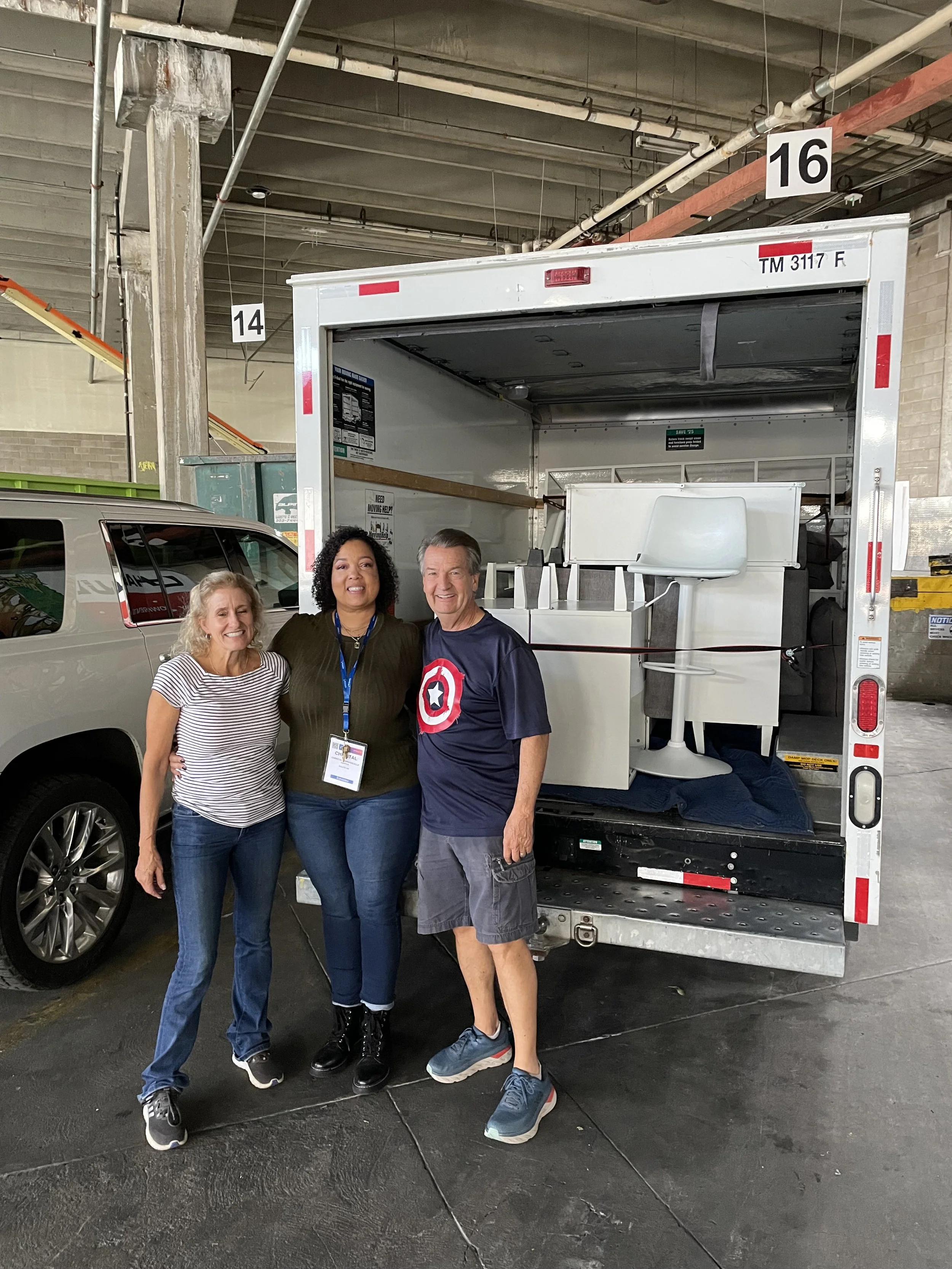 Christal taking a photo with the Angels in Denver team, beside the truck filled with post-event donations. 