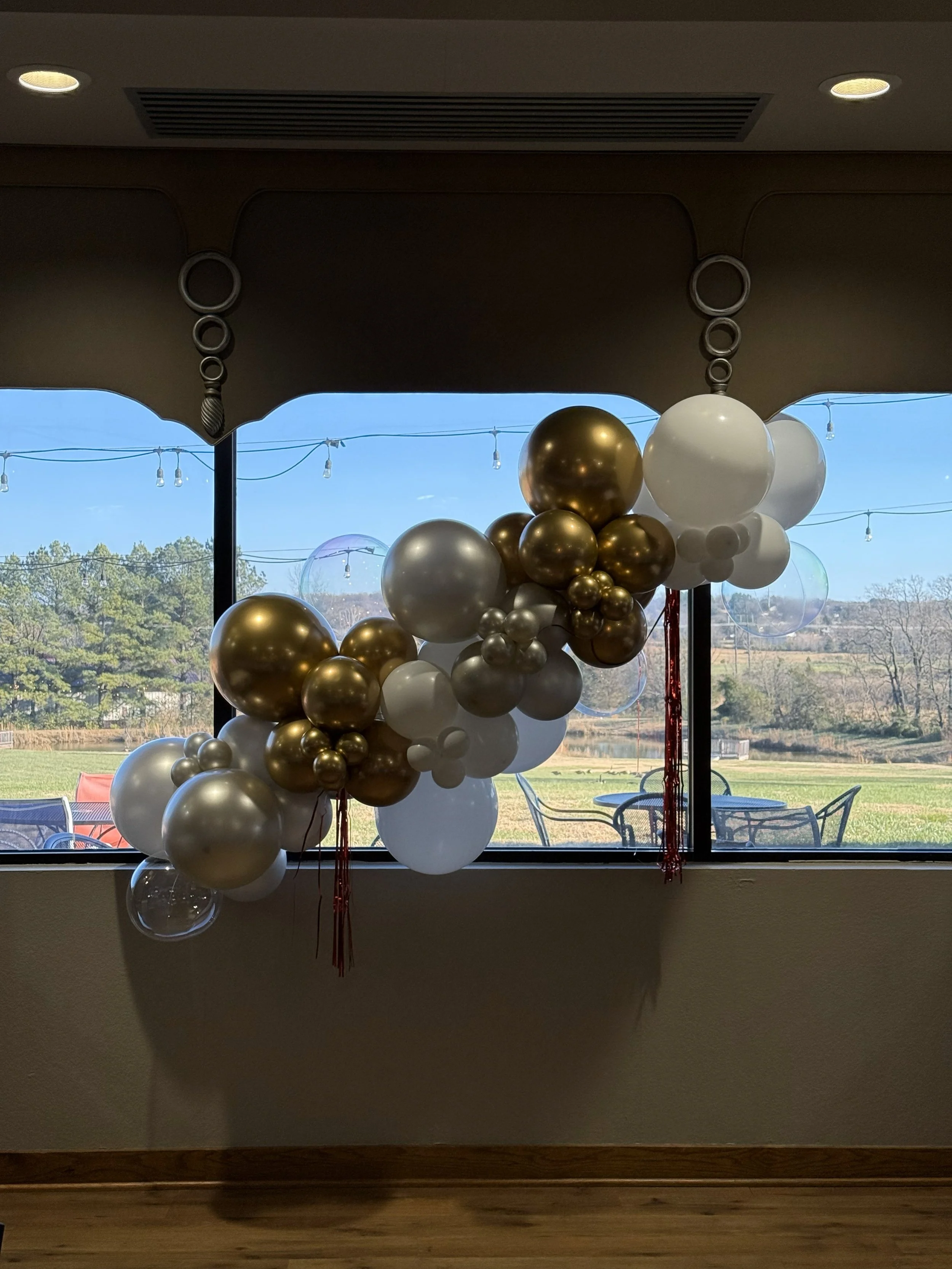 A cluster of colorful balloons floating against a dark blue sky.
