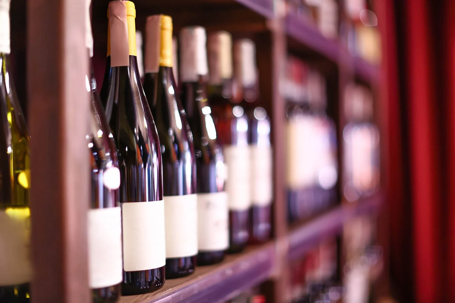 Shelves of wine bottles in a store or wine cellar.