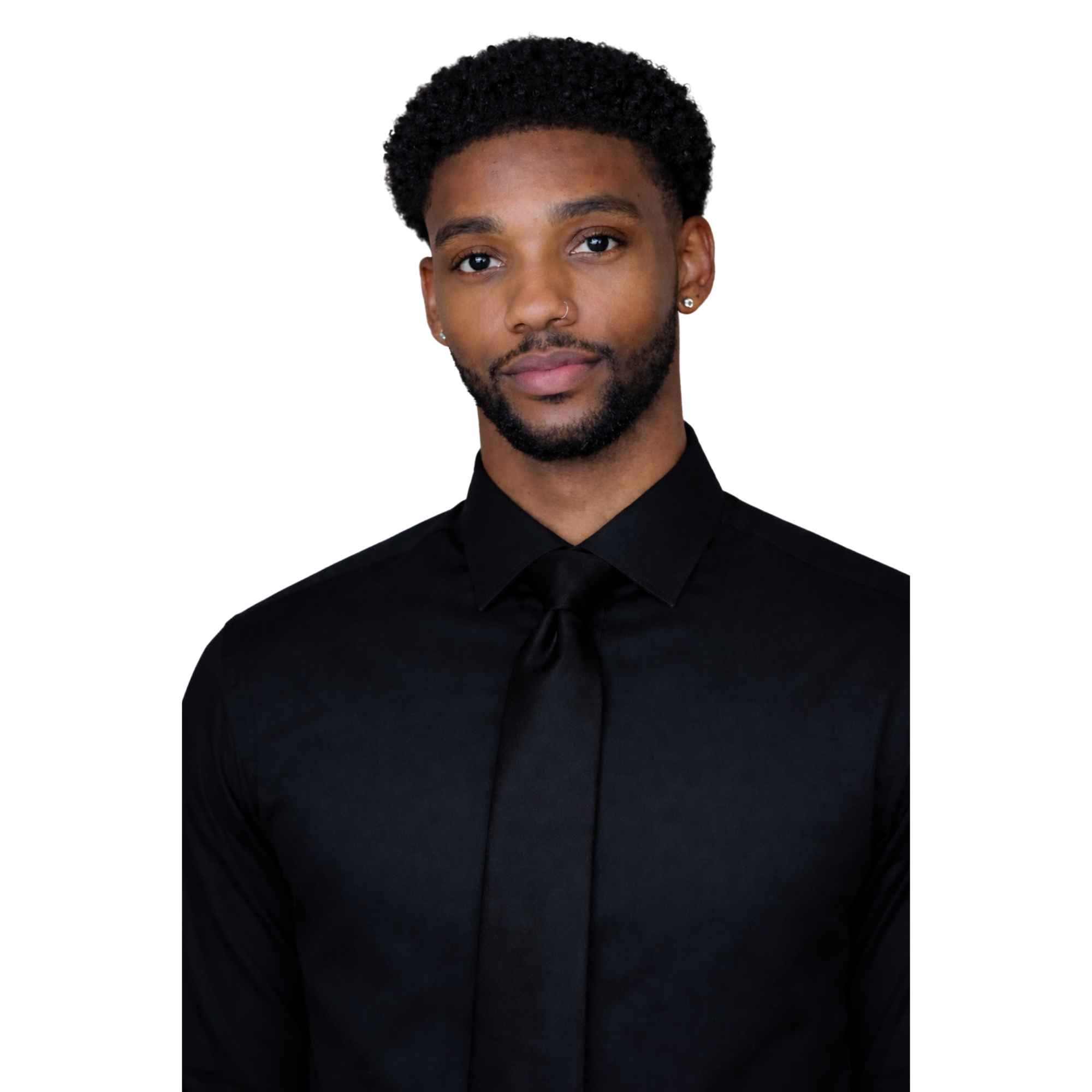 A young man with a short afro hairstyle and a beard, wearing a black dress shirt and black tie, looking into the camera against a dark background.