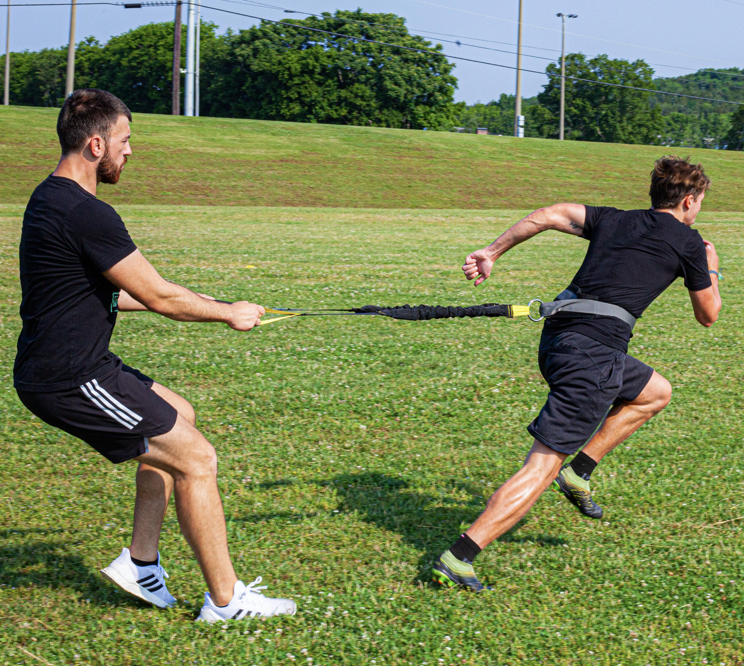 Coach working 1-on-1 with a soccer athlete using resistance training