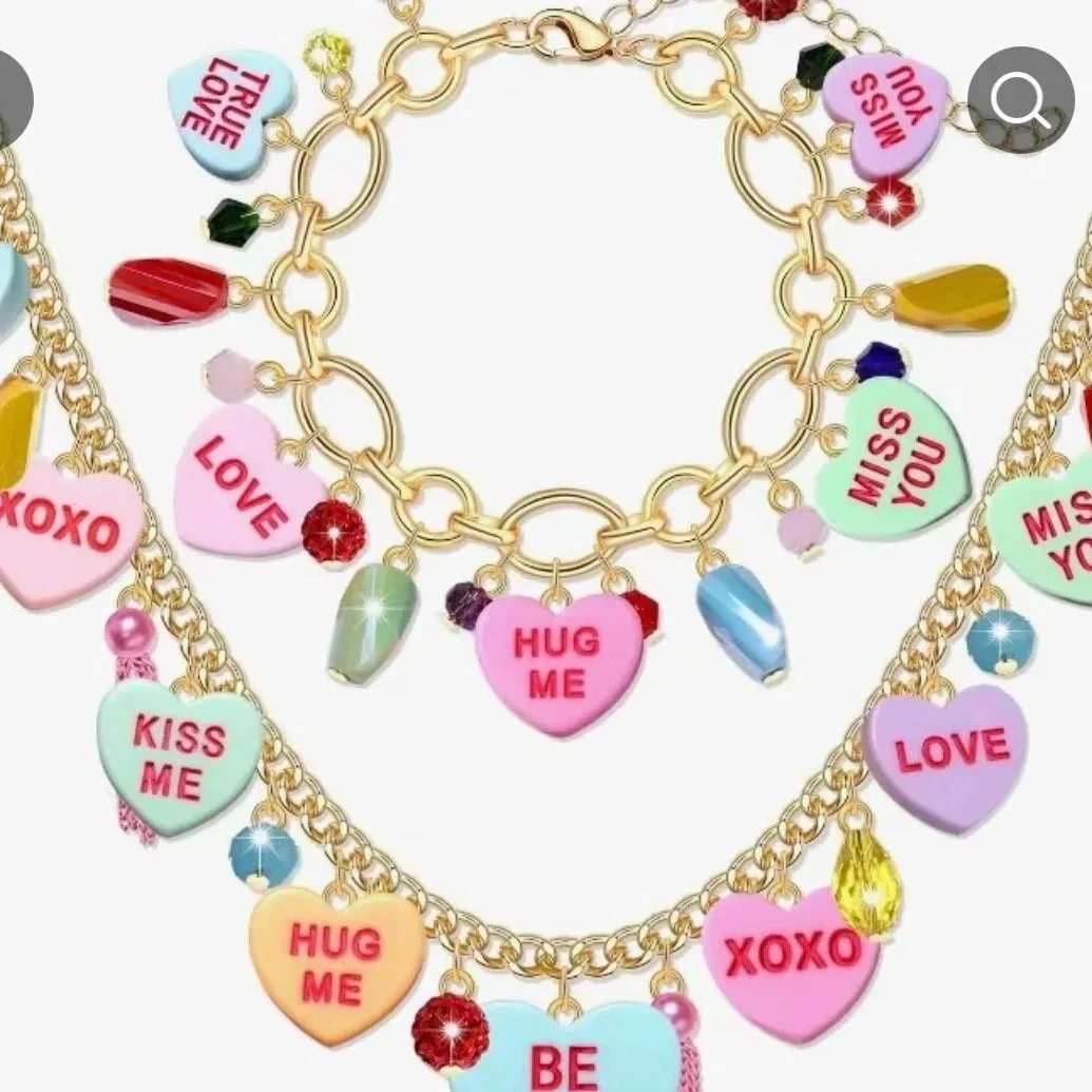 Charm bracelet with colorful heart-shaped charms bearing love messages like "HUG ME," "KISS ME," "LOVE," and "MISS YOU," along with various pendants and beads on a gold chain.