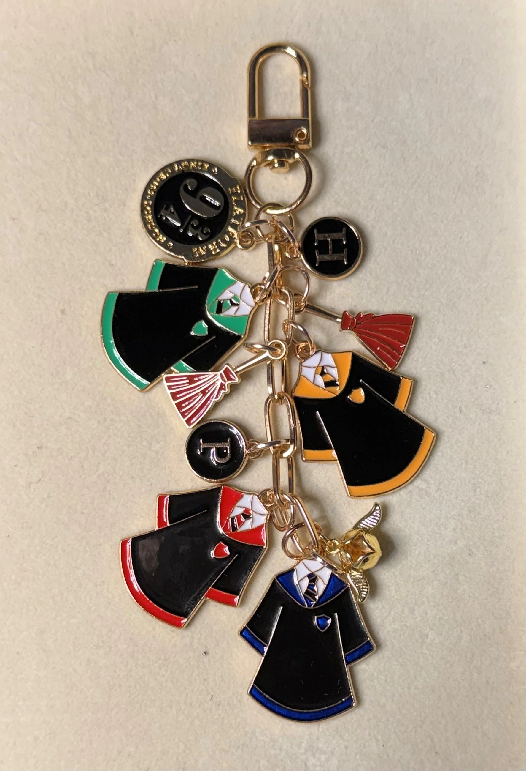 A keychain with charms of various people dressed in formal gowns and tuxedos, each with a different color and style.