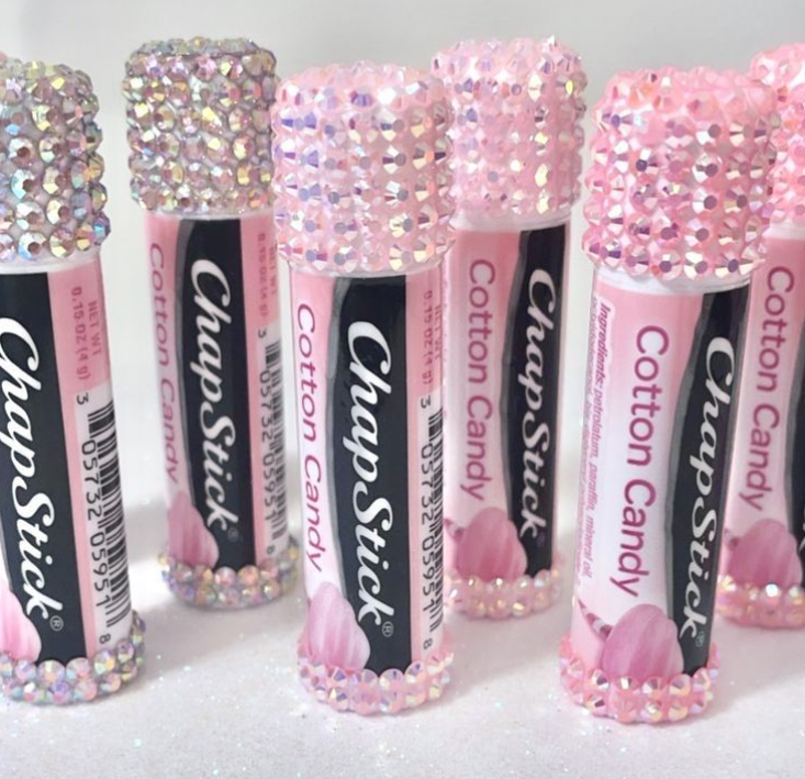 Pink cotton candy flavored ChapStick lip balm tubes with rhinestone-encrusted caps, arranged on a white surface