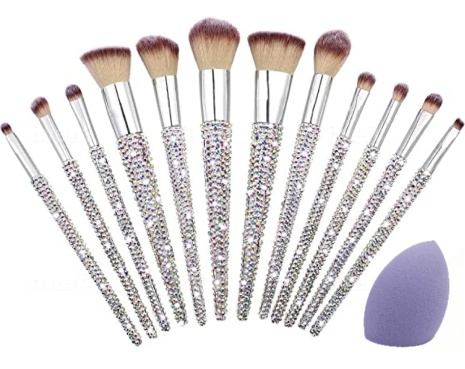 Set of 12 rhinestone makeup brushes with beige bristles, and a purple makeup sponge.