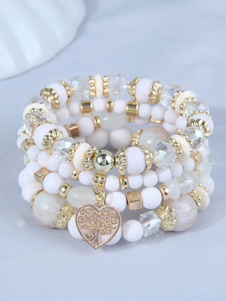 A set of white and gold beaded jewelry, including bracelets with a heart-shaped charm.