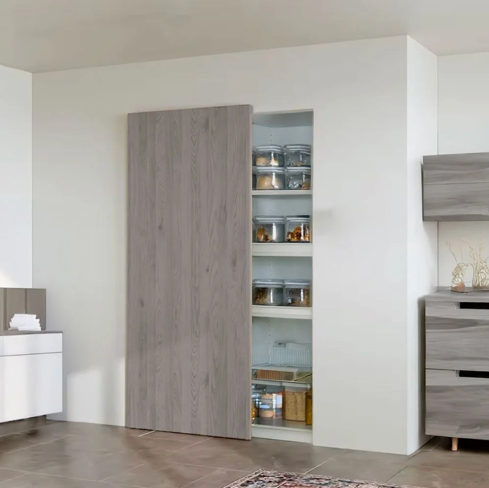 White built-in pantry with wooden sliding door partially open, revealing glass containers and kitchen items inside.