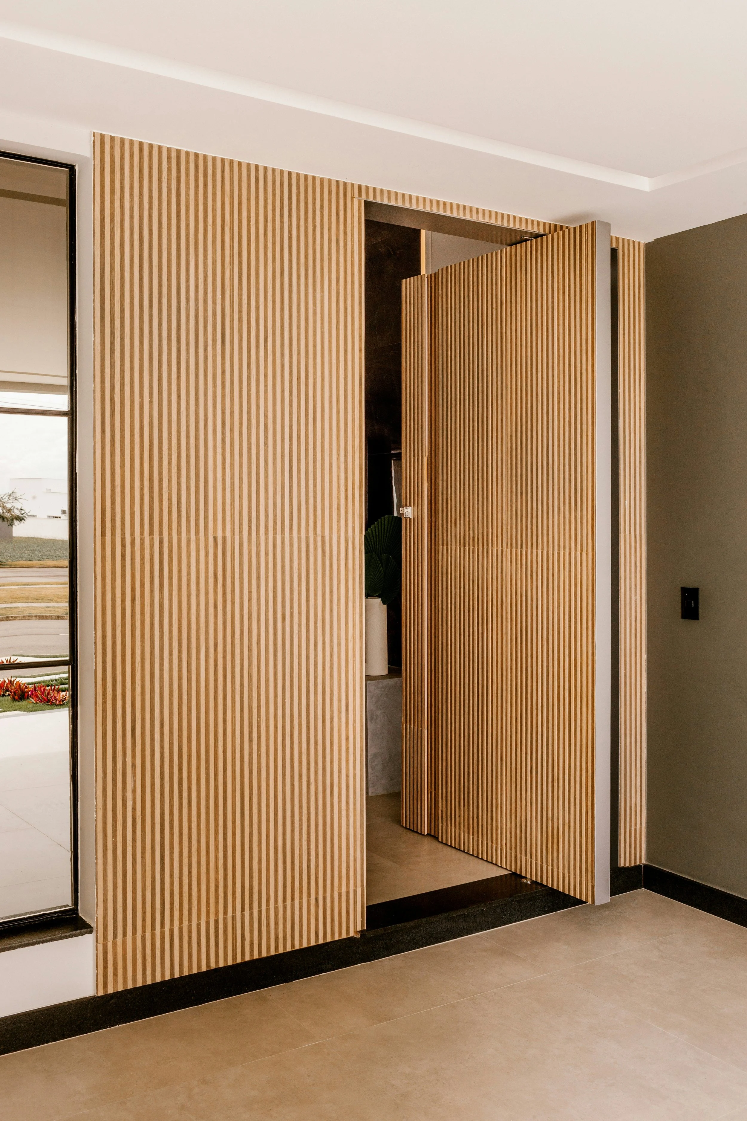 Interior view of a room with wooden slatted foldable door panels, partially open, revealing a decorated space inside.