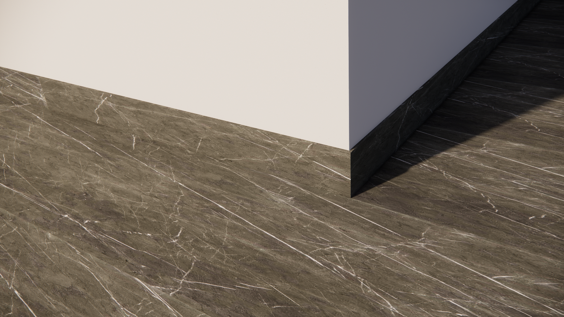 Close-up of a corner where a white wall meets a dark marble baseboard and brown marble flooring with white veining.