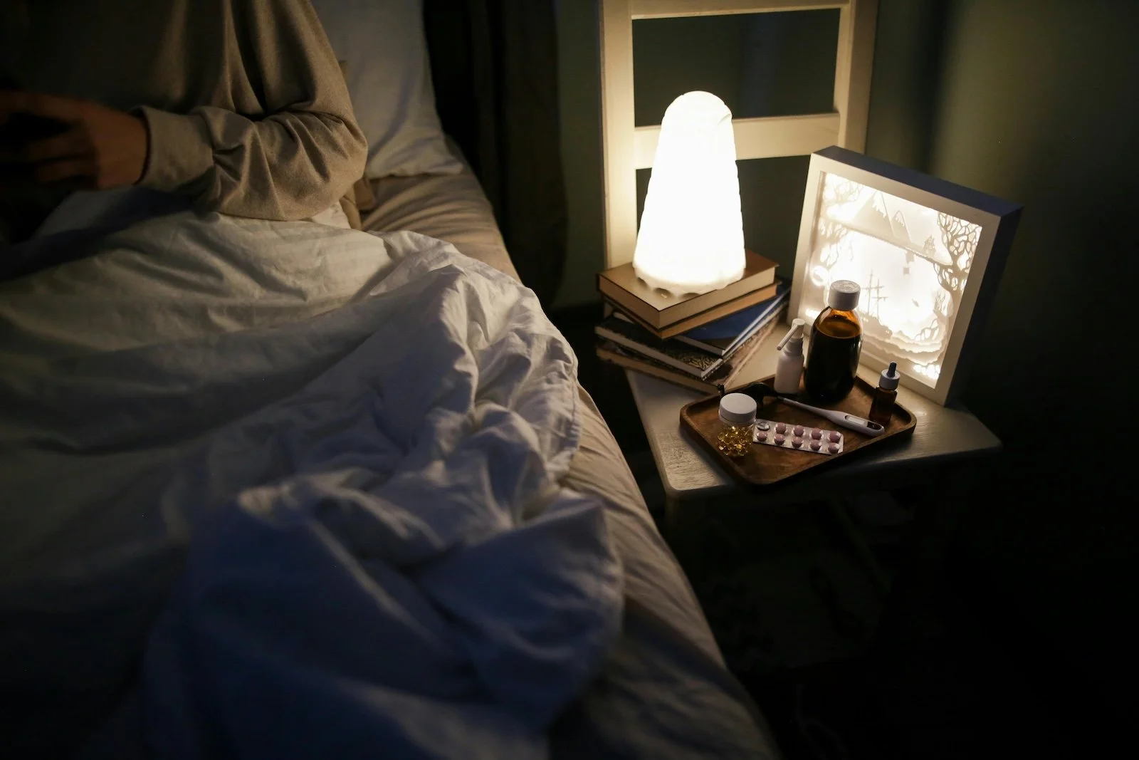 Bedside table with book and lamp as part of a calming night routine