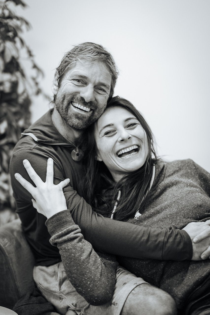 A happy man and woman are hugging and smiling in a black-and-white photo.