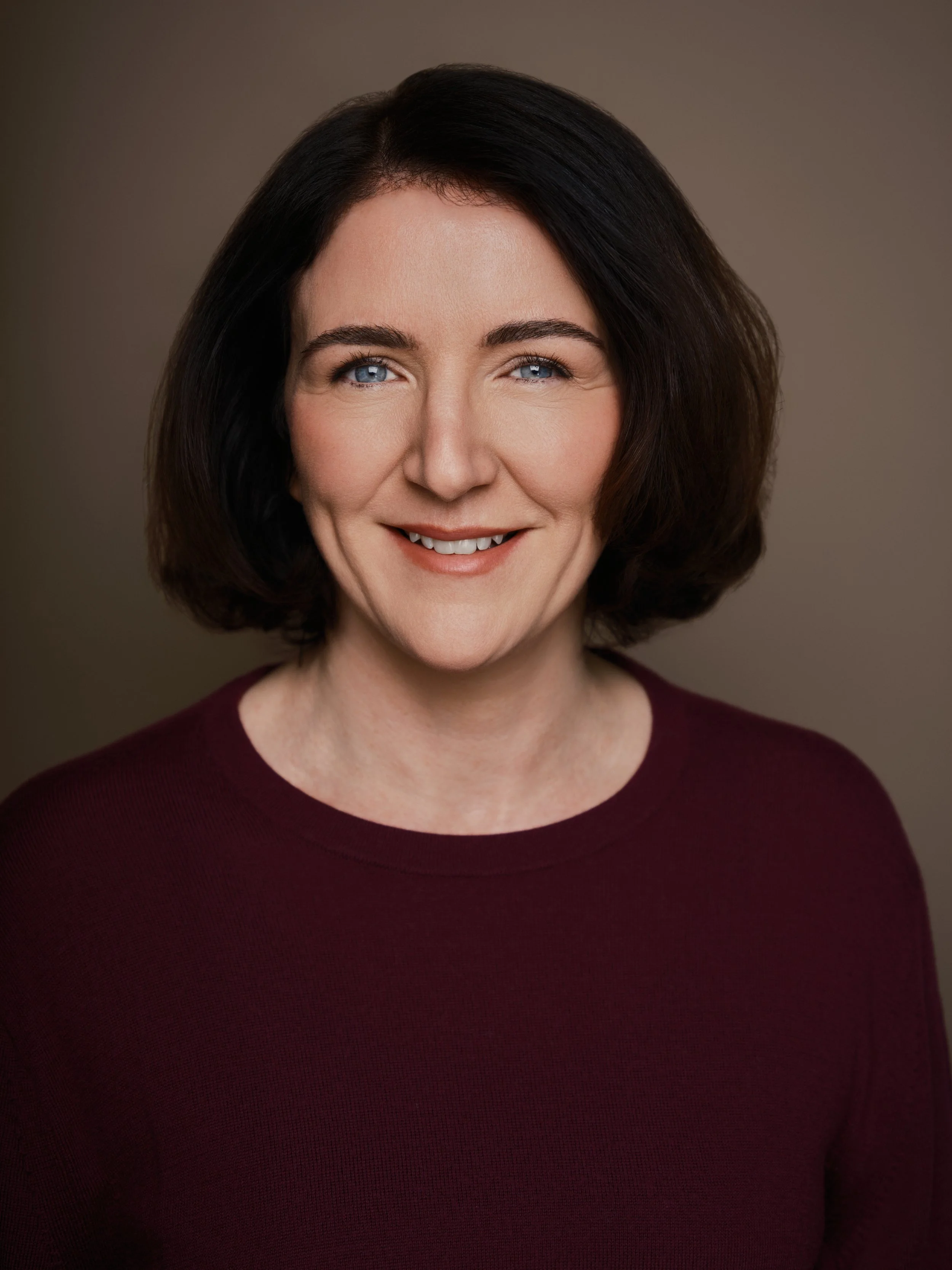 Business headshot of a smiling professional woman, Luke Nugent Portraits London