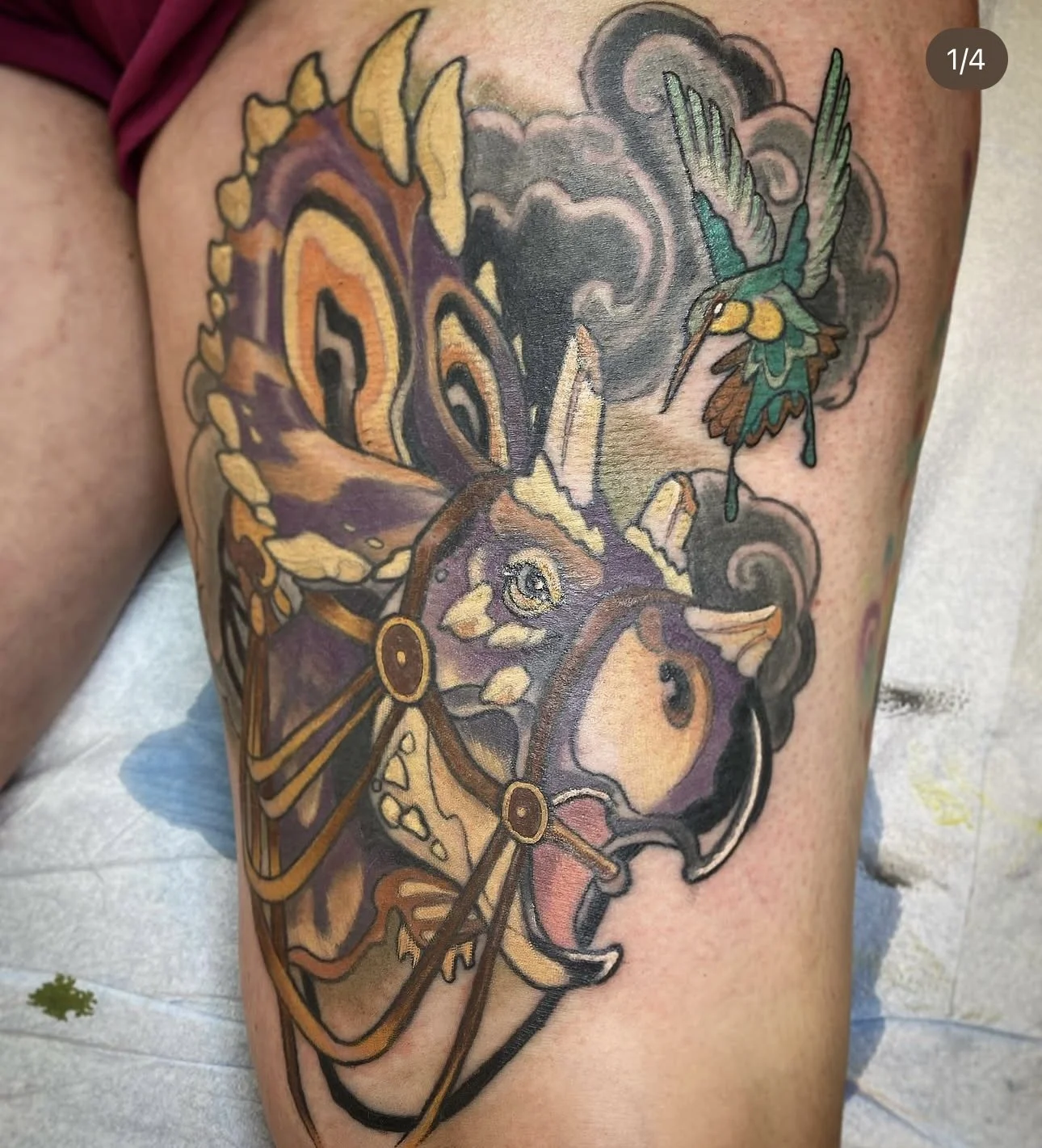 Tattoo of a butterfly and a hummingbird on skin, with colorful details and shading.