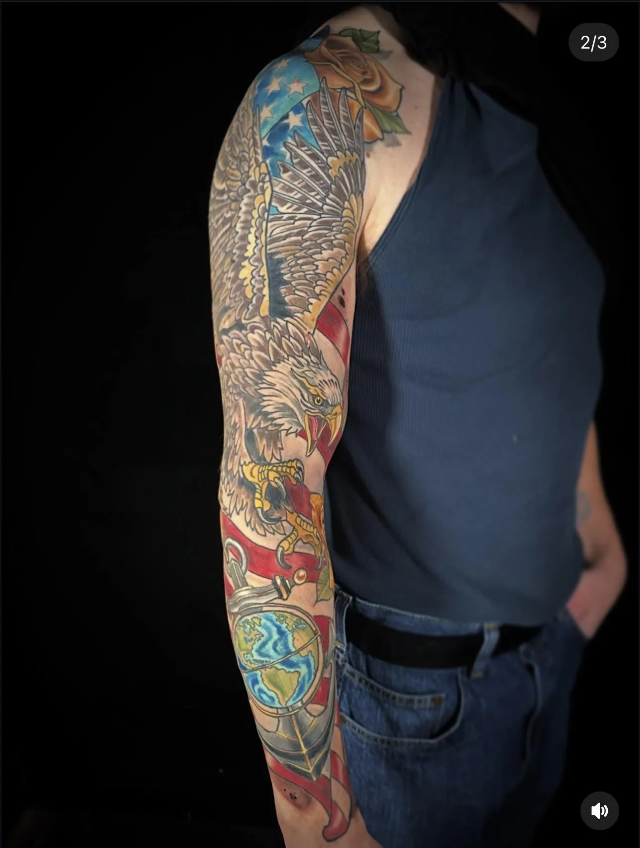 Colorful tattoo sleeve featuring an eagle, American flag, and the planet Earth on a person's arm.