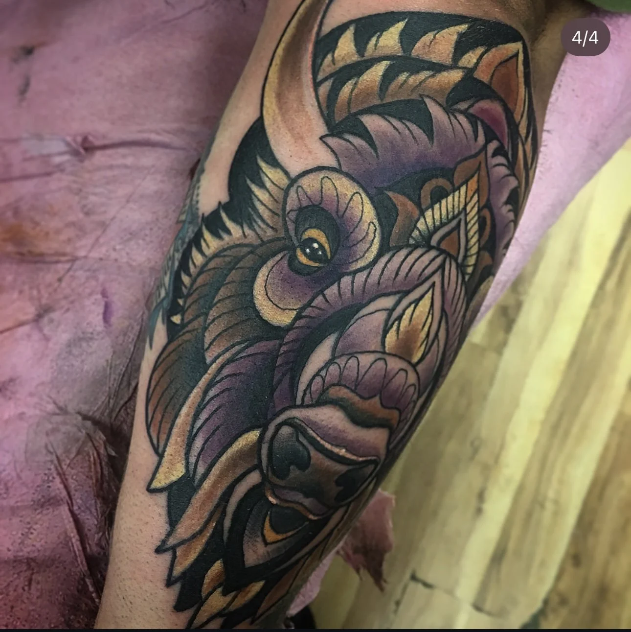 Colorful tattoo of a wolf on a person's arm, featuring detailed lines and shading.