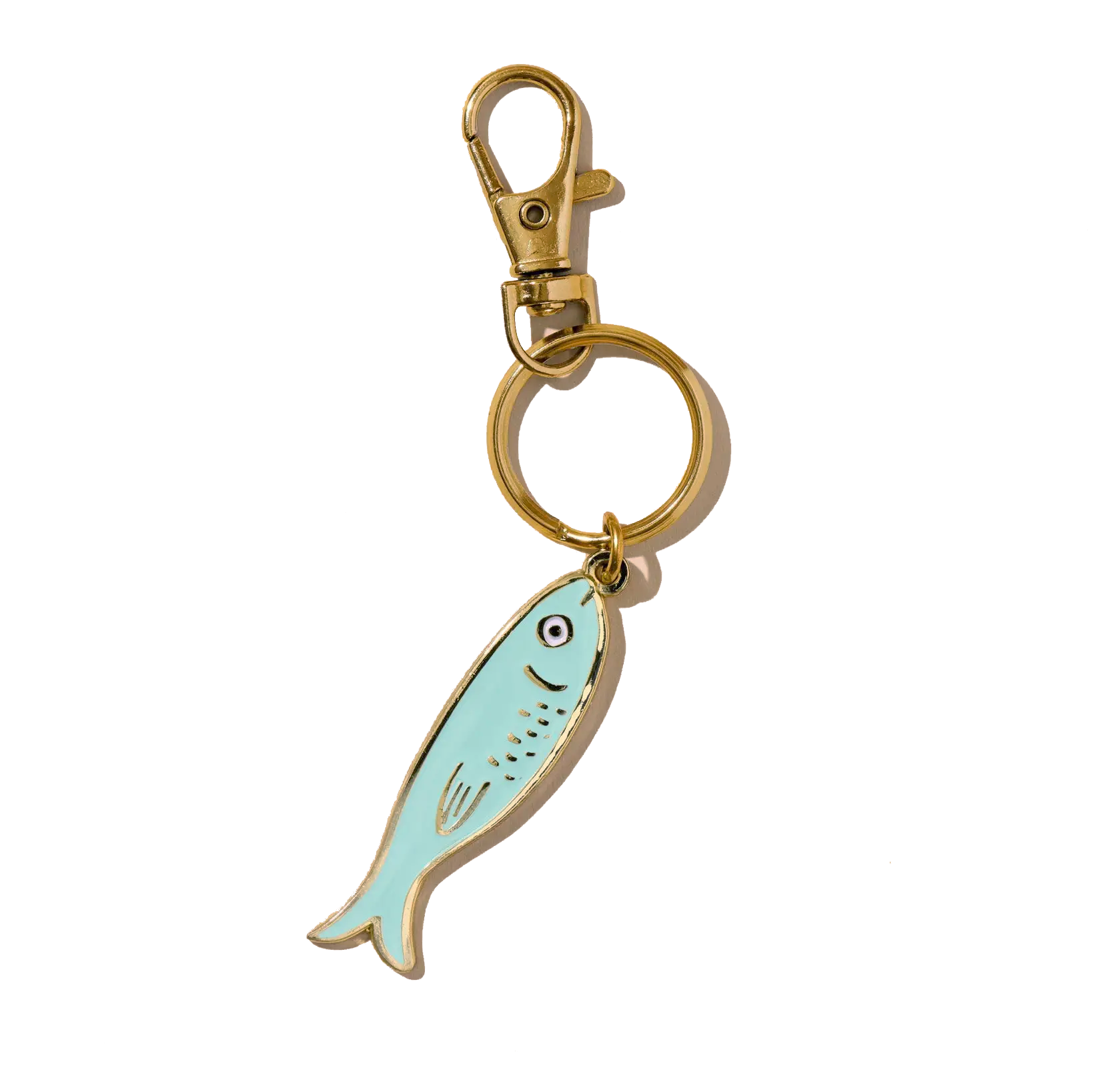A keychain with a gold ring, a lobster clasp, and a fish-shaped charm with a smiling face, all set against a light background.