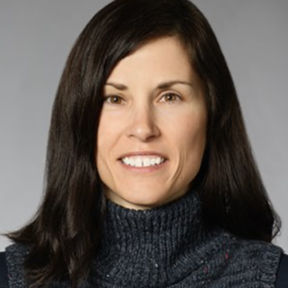 Portrait of a woman with straight dark brown hair, wearing a dark turtleneck sweater, smiling against a gray background.