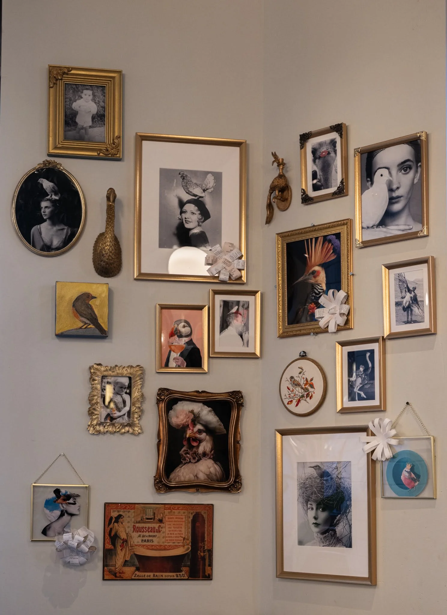 A gallery wall with various framed photos and artworks, including portraits, animals, and artistic images, arranged in a somewhat eclectic pattern.