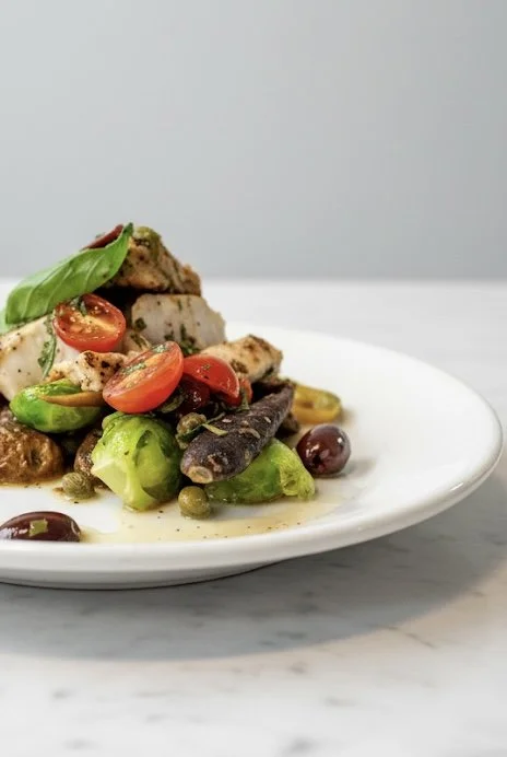 Assorted grilled vegetables and cherry tomatoes on a white plate.