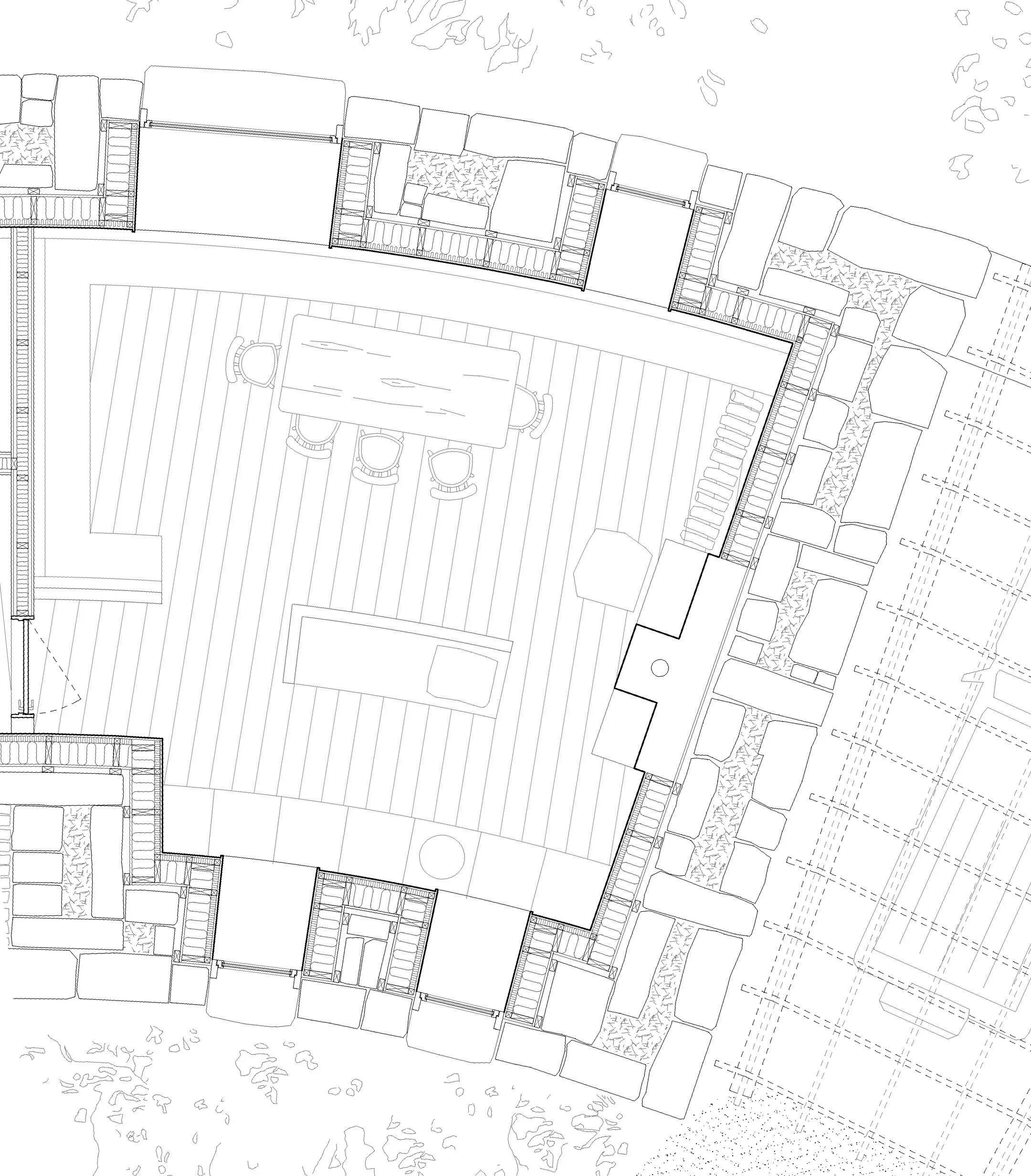 Architectural floor plan of a building with a central patio, including a dining area with a table and chairs, outdoor seating, and surrounding walls and landscaping.