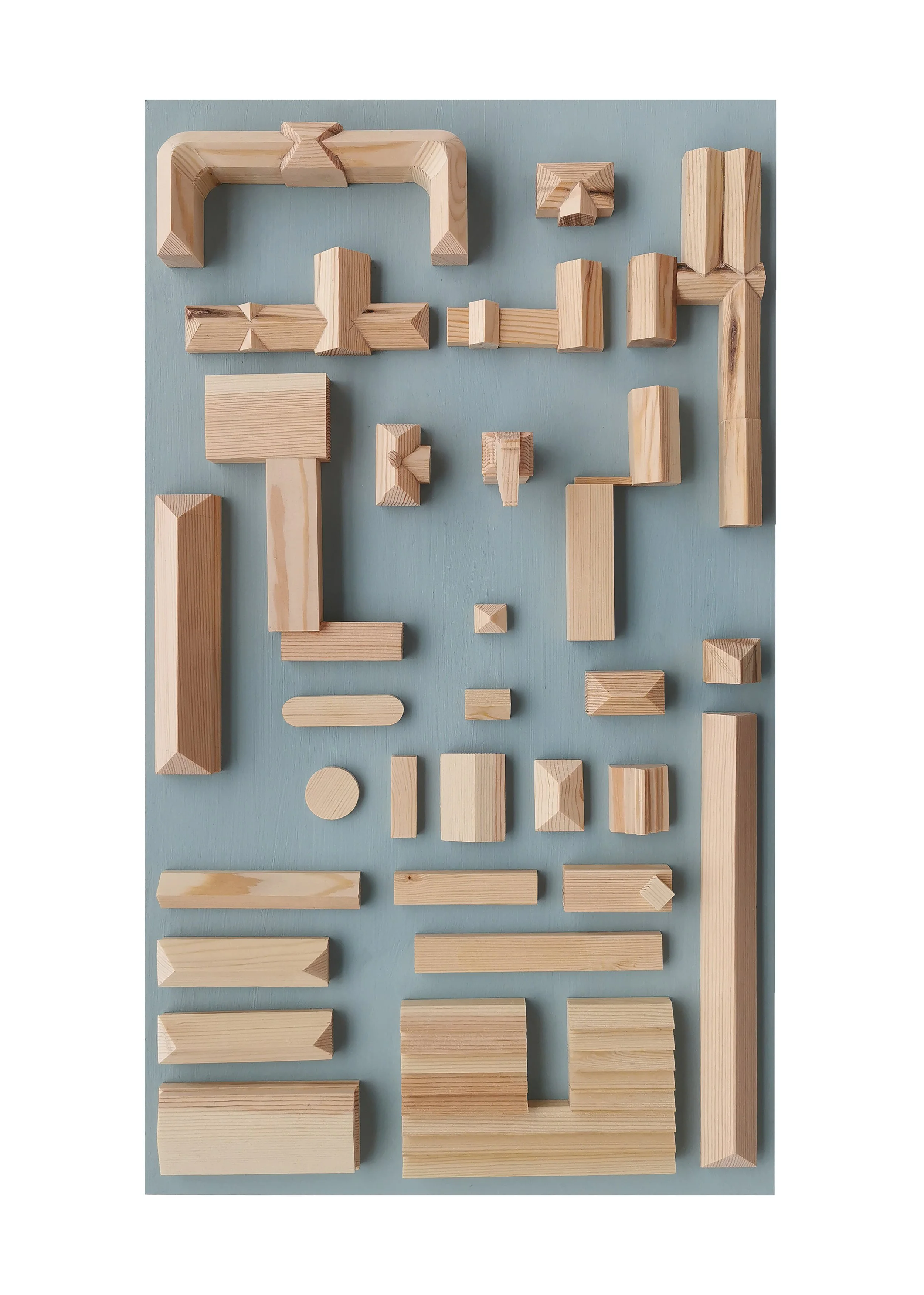 Various wooden building blocks arranged on a light blue surface.