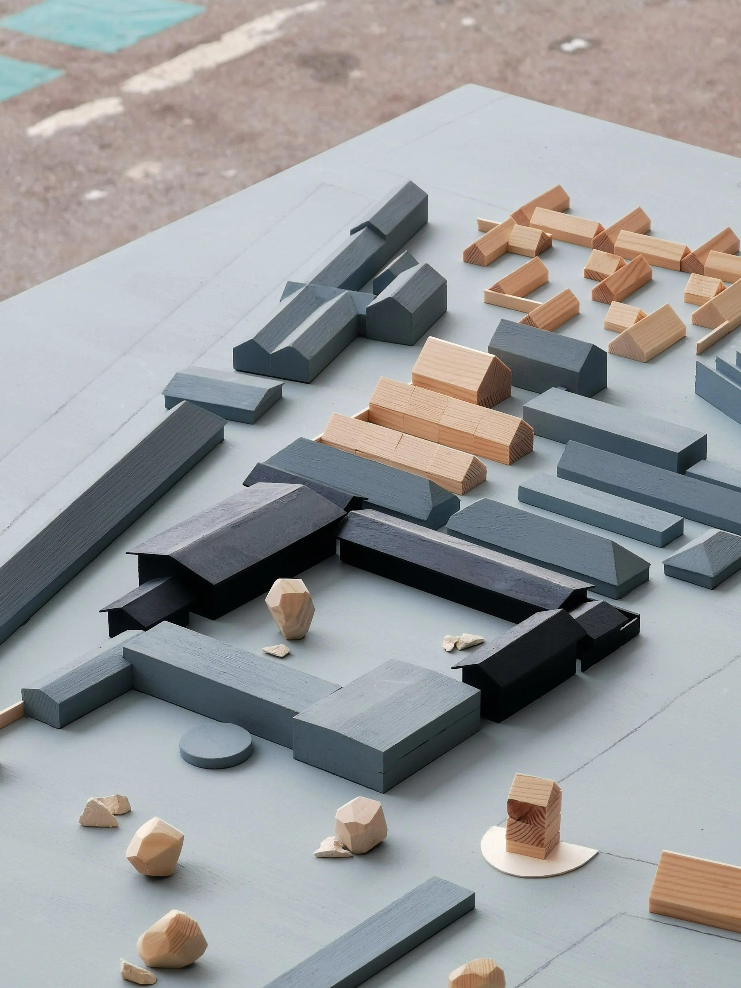 Arrangement of various wooden building blocks in different shapes and colors on a table.