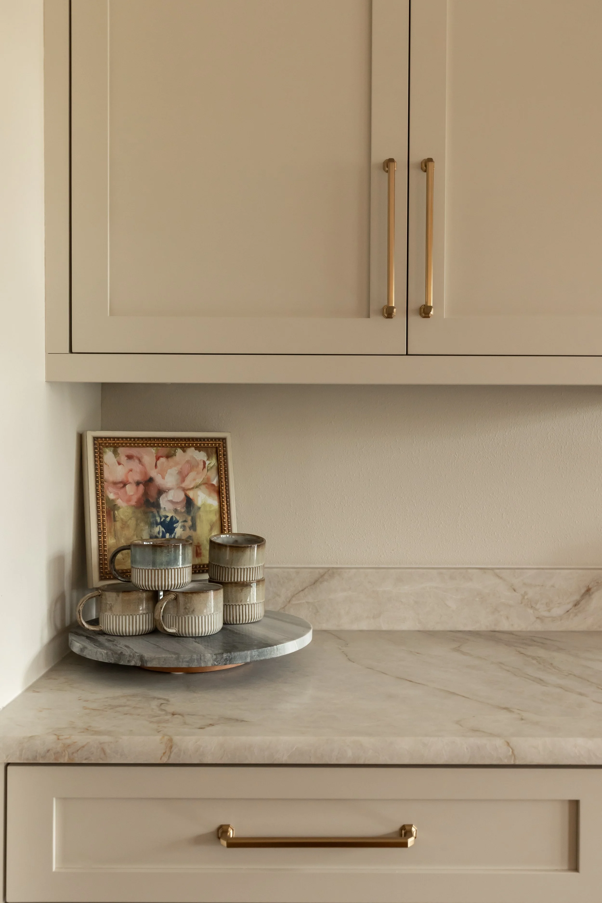 Polished brass hardware brings a subtle warmth and reflective quality to the cabinetry. The streamlined pulls balance classic design with a modern edge.