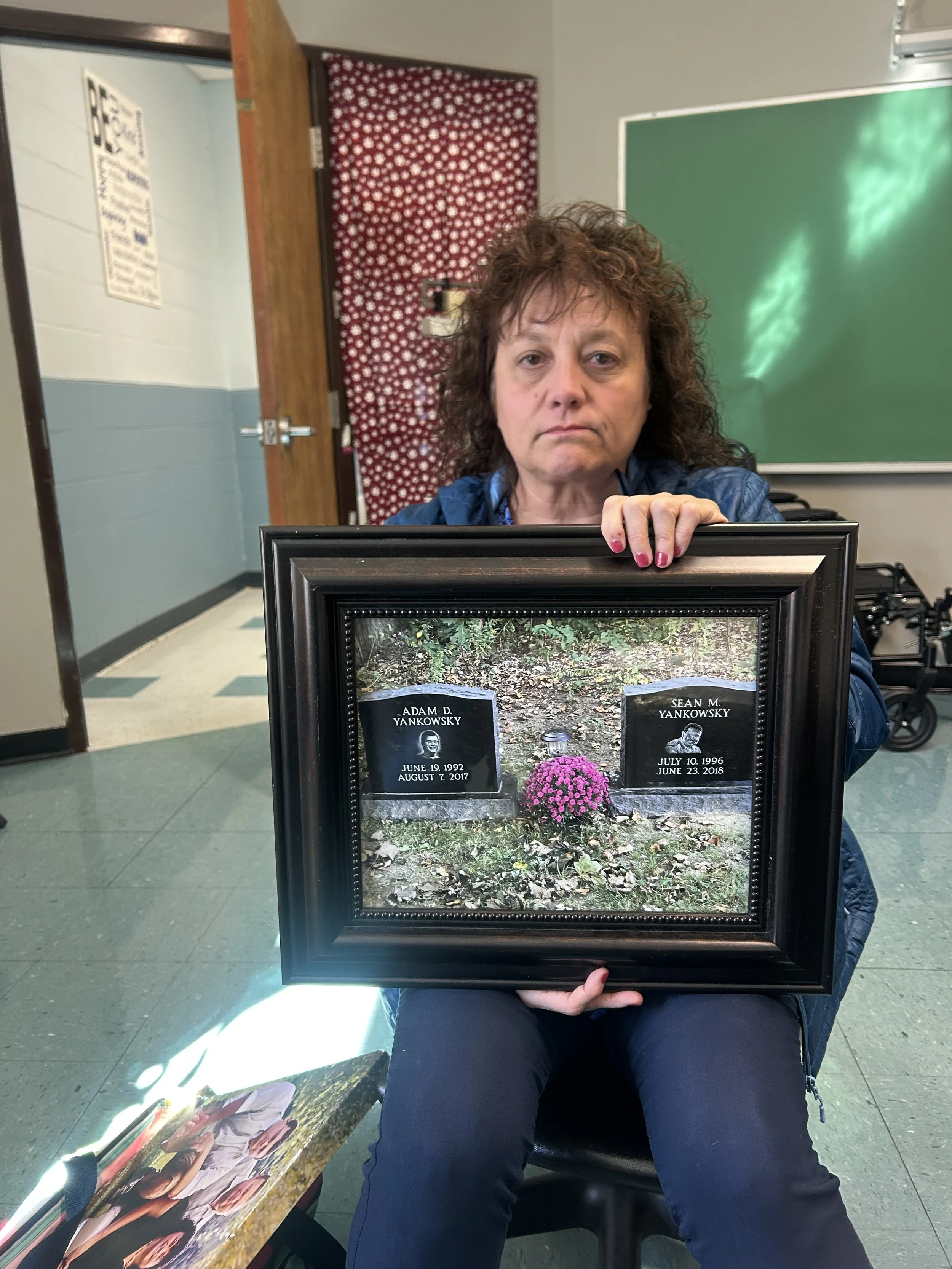 Yankowsky with a photo of her two sons' gravestones.