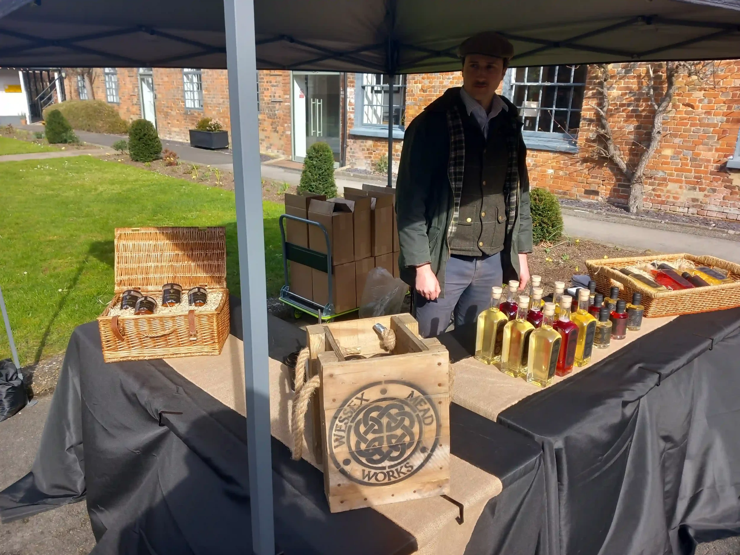 Man behind market stall selling alcohol.