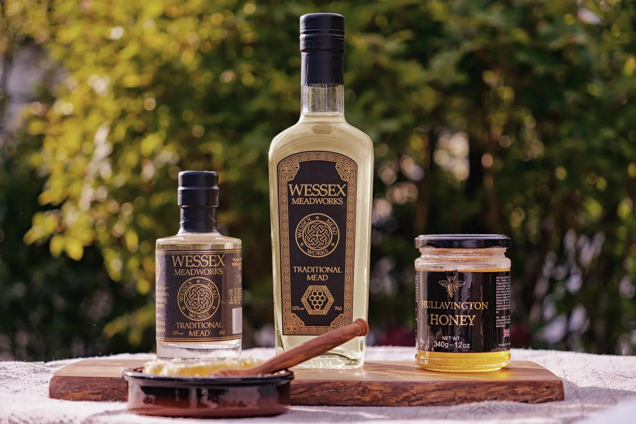 Bottles of Wessex Meadworks mead, jar of honey, honeycomb in dish with twizzler