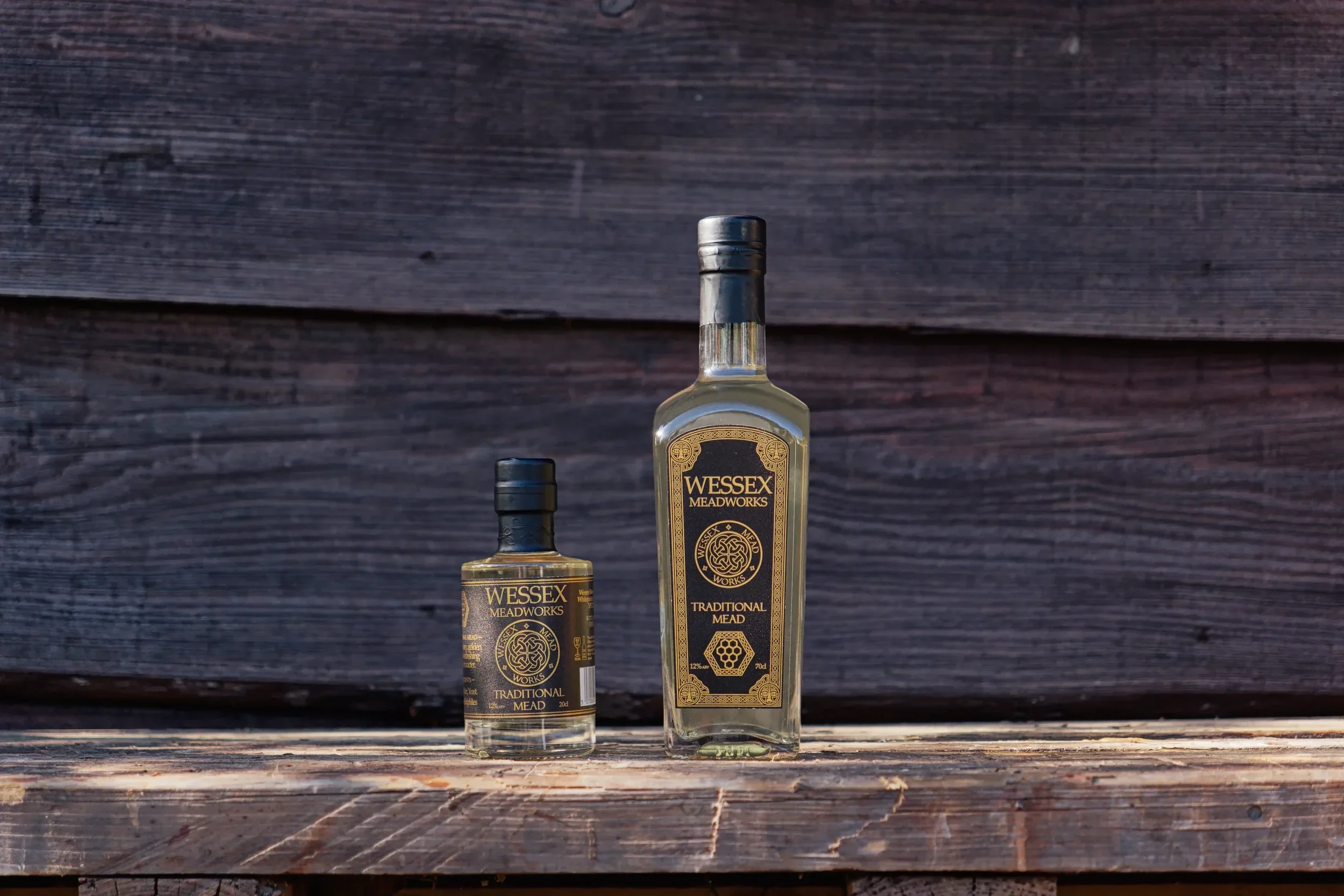 Wessex Meadworks Large and Small bottles, wood background and table.