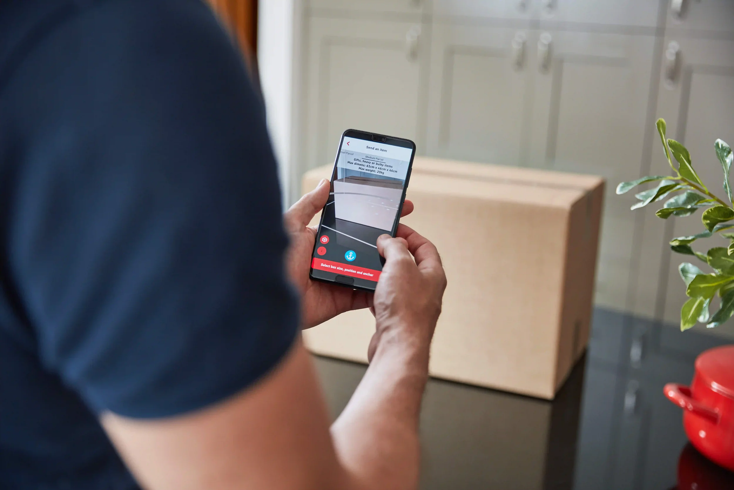 Man using phone to take photo of parcel.