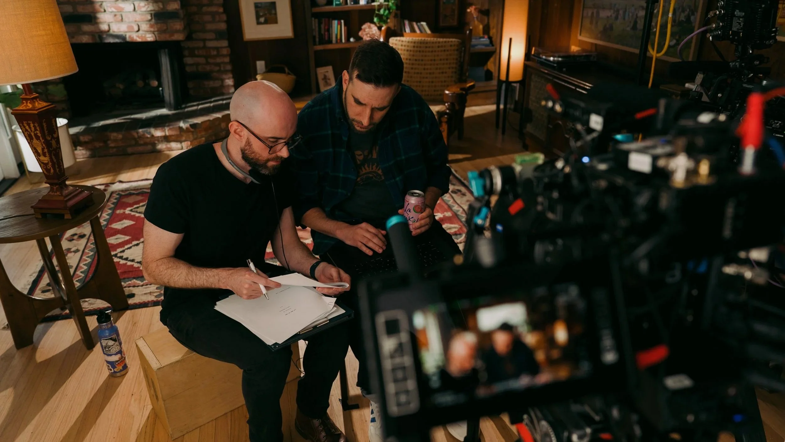 Justin and Alex plan out a script for a commercial shoot in front of a cinema camera