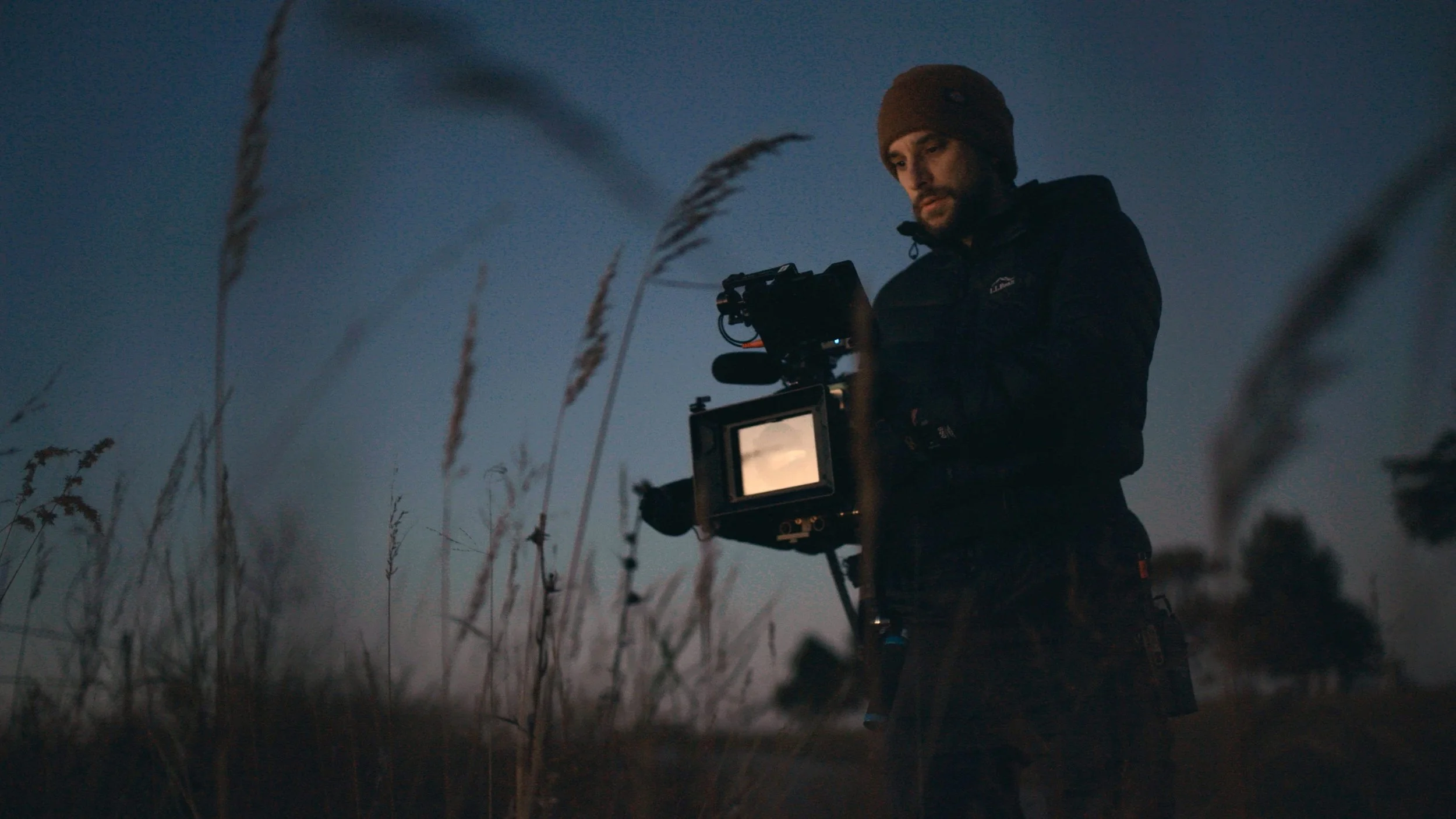 Cinematographer capturing high-end cinematic visuals at twilight shoot on commercial production.