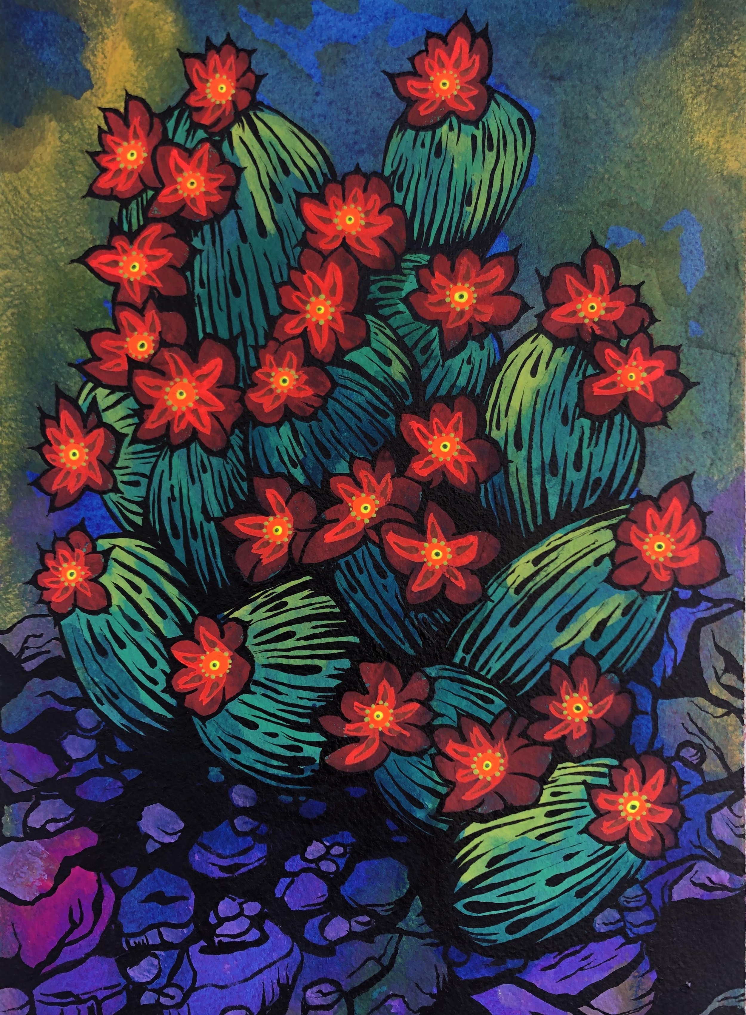 A desert painting featuring a cactus bloom with layered green pads and vivid red flowers with yellow centers, surrounded by cool blue and purple stone shadows and a textured blue-green sky.