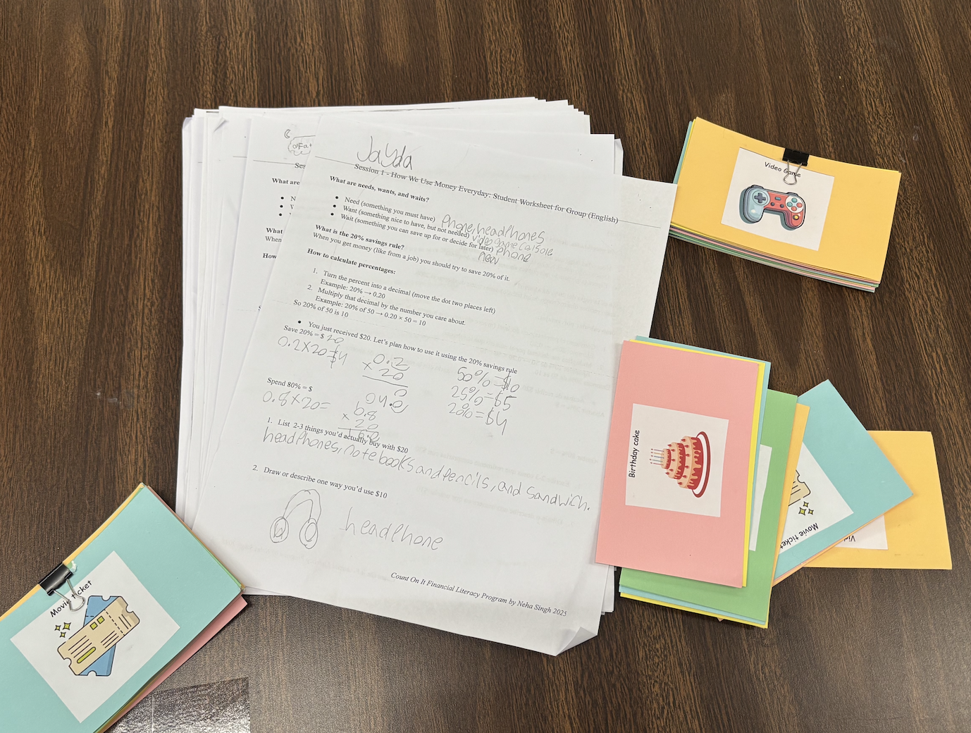 Educational worksheet on how to save money, surrounded by colorful flashcards with birthday cake, movie ticket, and game controller icons.