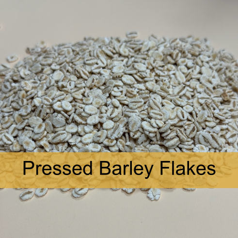 Close-up of pressed barley flakes on a surface with a label that reads 'Pressed Barley Flakes'.