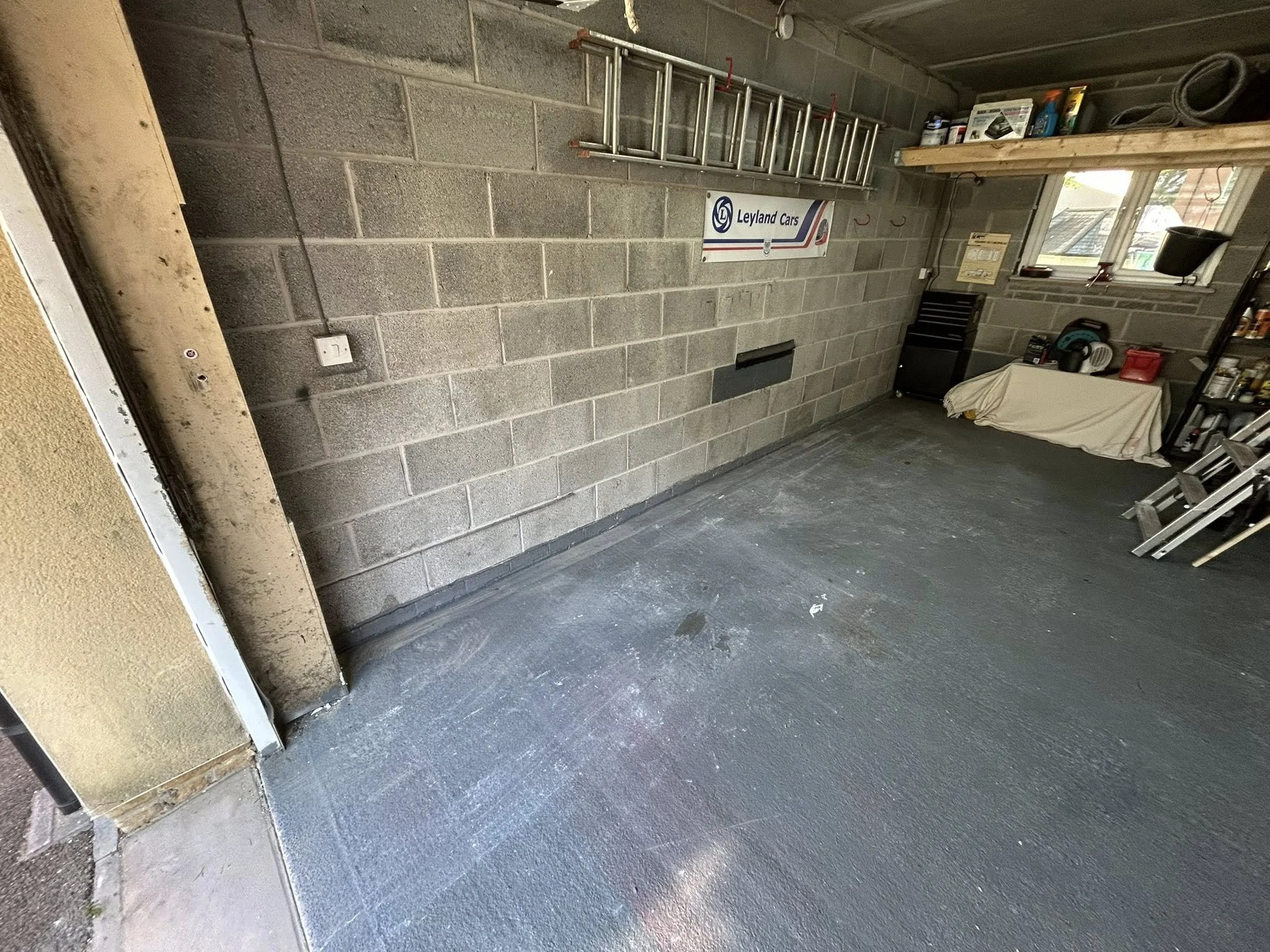 Inside a garage with gray cinder block walls and a concrete floor.
