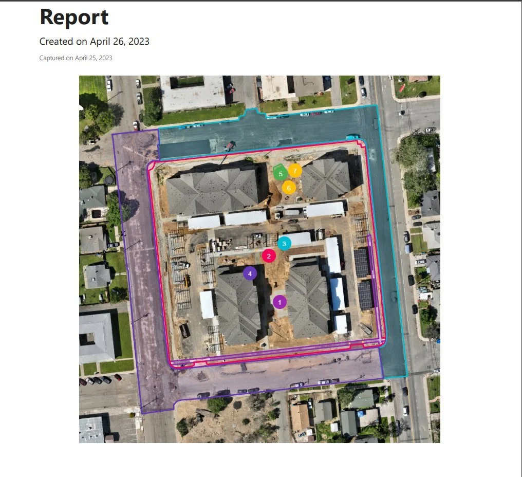 Aerial view of a construction site with buildings, marked zones, and surrounding streets, indicating different areas with numbered colored markers.