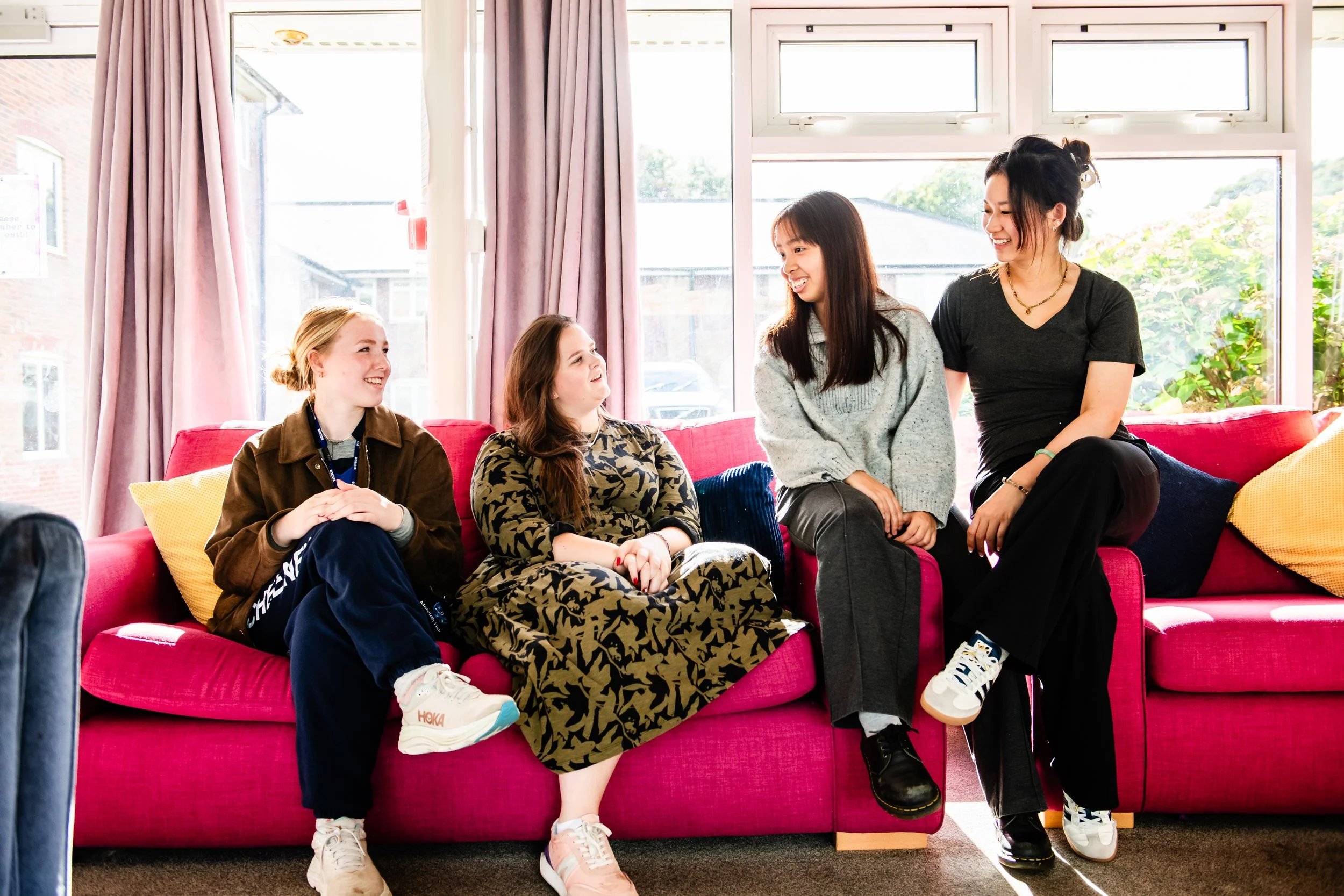 Student engaging in a conversation inside a bright, casual living room.