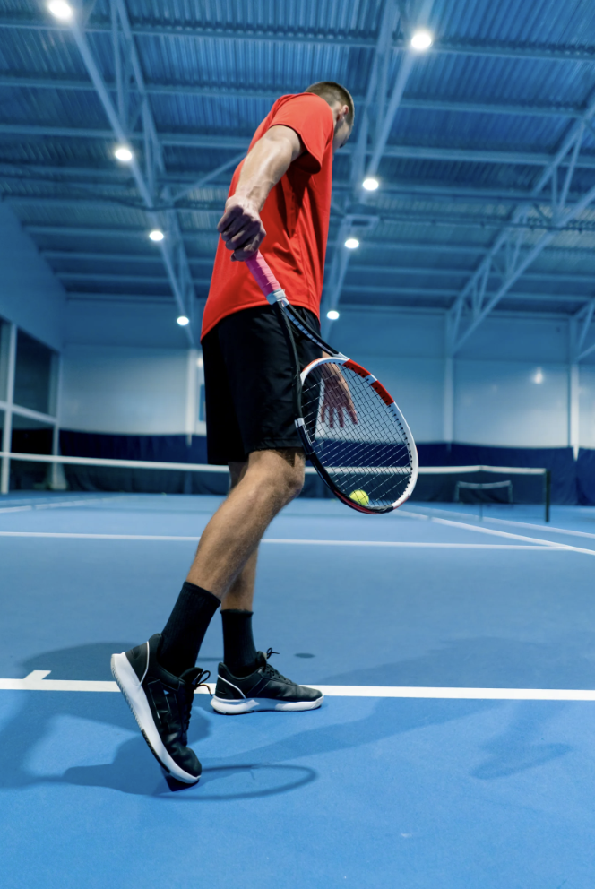 A man about to serve a tennis ball.
