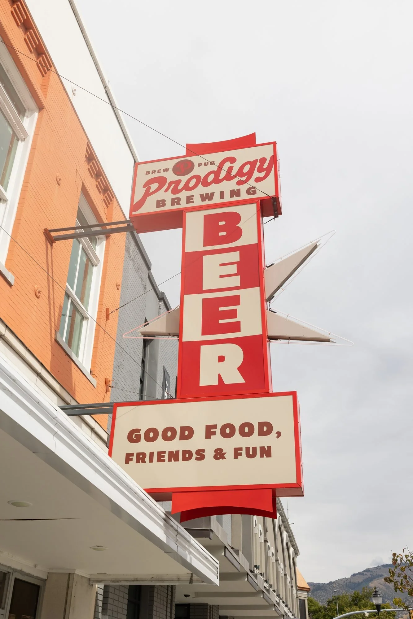 Prodigy Brewing sign reading Good Food, Friends and Fun against the sky in Logan, Utah