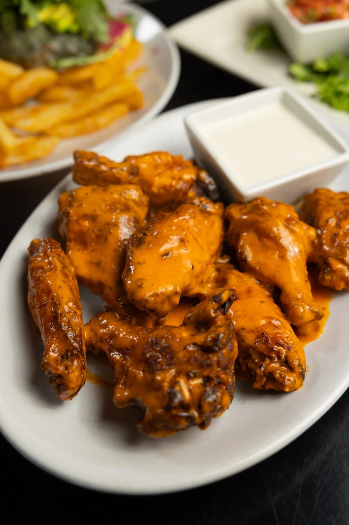 Buffalo wings with ranch on a white plate at Prodigy Brewing in Logan, Utah