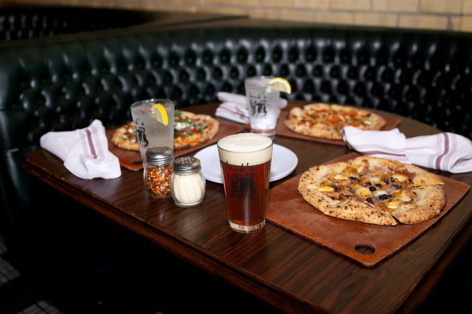 Booth set with two pizzas and drinks at Jack's Wood Fired Oven in Logan, Utah