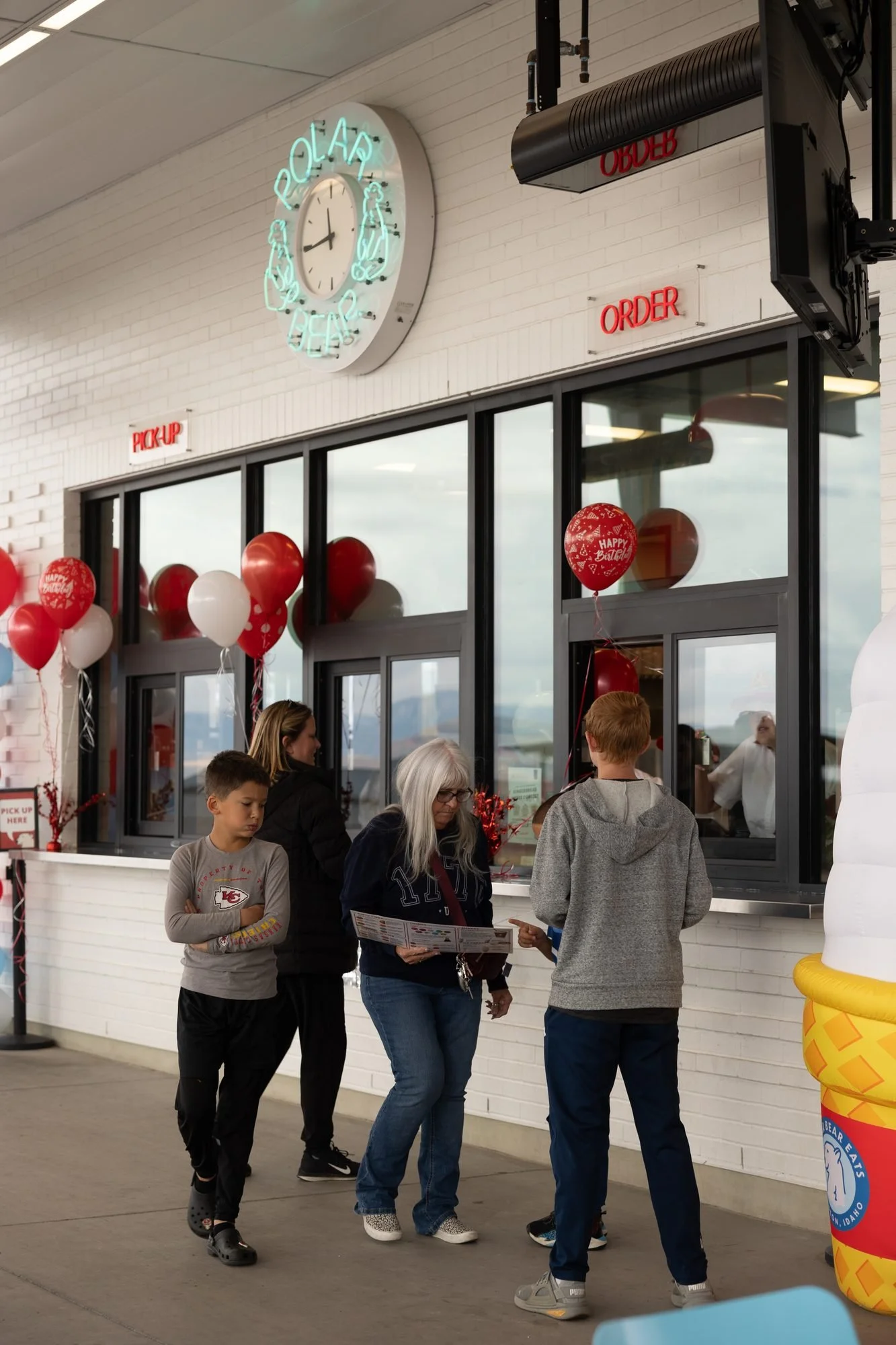 Customers walk up to the order windows at a Polar Bear shop decorated with red balloons