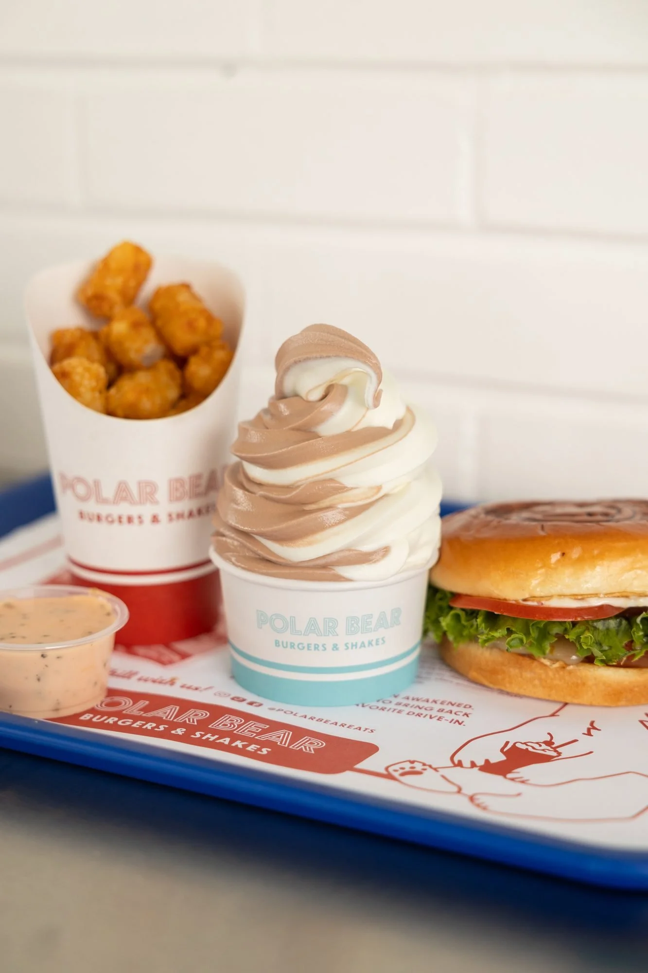 A Polar Bear tray with tater tots, a soft-serve cup and a burger