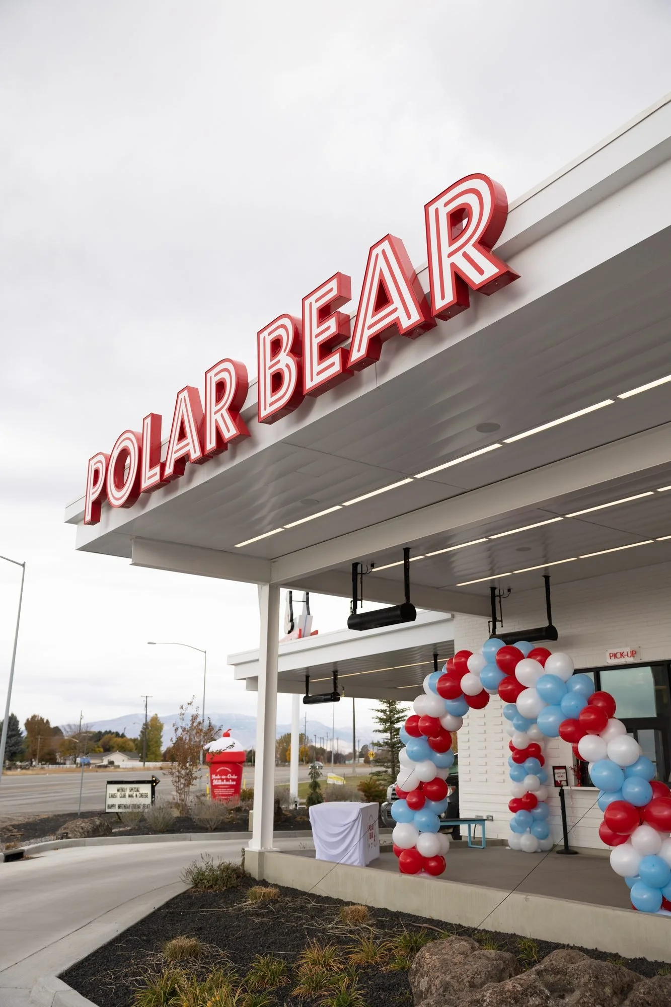 A Polar Bear drive-in canopy with its red sign and a balloon arch at the entrance