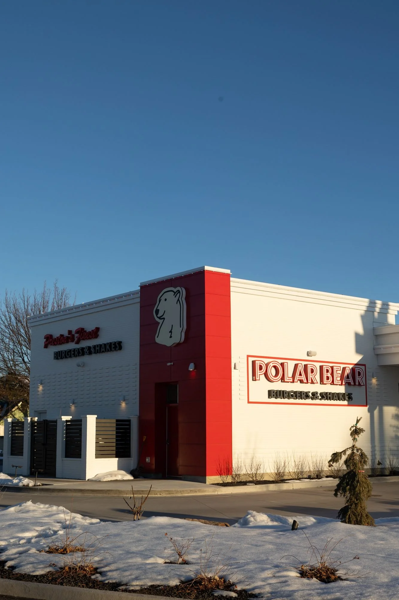 A white and red Polar Bear Burgers building with snow on the ground under a clear blue sky
