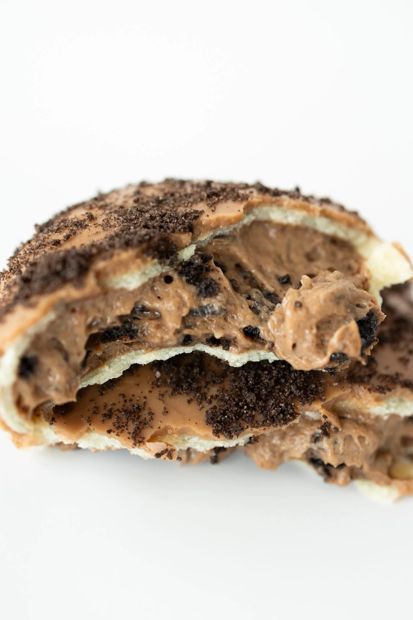 A broken open hand pie with a chocolate cookie crumble topping and creamy chocolate filling
